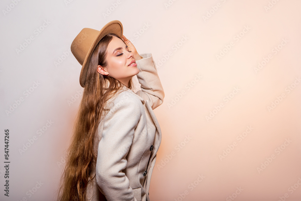 Fashion Portrait Beautiful Young Woman in a light fashionable coat and a beige stylish hat Fashion Portrait Beautiful Young Woman in a light fashionable coat and a beige stylish hat