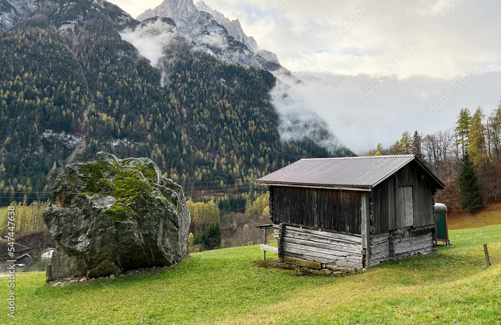 Traditional Swiss architecture and wooden alpine houses in the autumn environment of mountain pastures and mixed forests in the Taminatal river valley, Vättis - Canton of St. Gallen, Switzerland