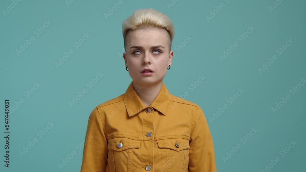 Charming girl in her 20s, with blonde, short hair rolling her eyes