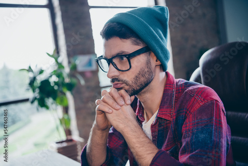 Photo of ponder pensive serious programmer wear spectacles hands arms chin indoors workplace workshop home