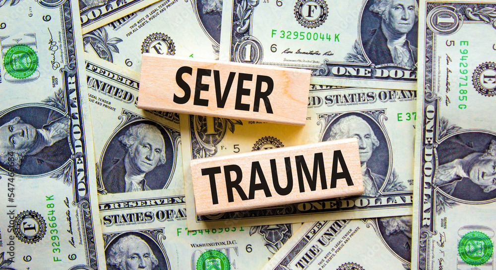 Sever trauma symbol. Concept words Sever trauma on wooden blocks. Beautiful background from dollar bills. Psychological and sever trauma concept. Copy space.