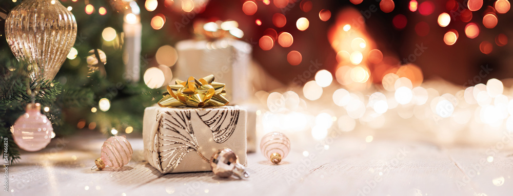 Christmas gifts with bright illumination lights on a light wooden background near a fireplace with fire Christmas gifts with bright illumination lights on a light wooden background near a fireplace with fire