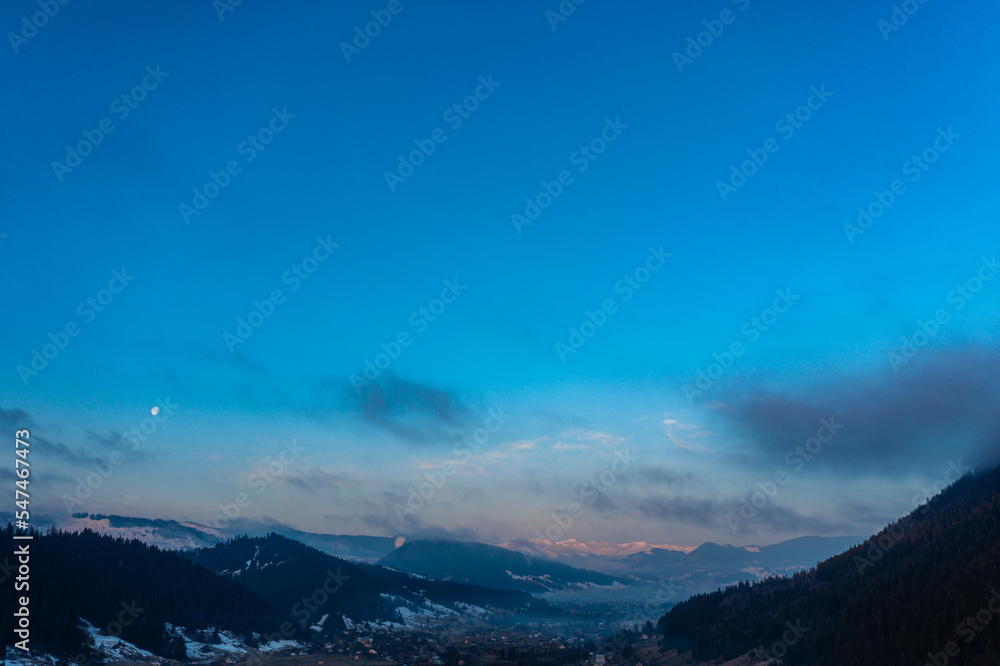 Mountain atmospheric landscape of high mountains in thick fog in rainy weather, panorama of mountain tops in thick clouds.