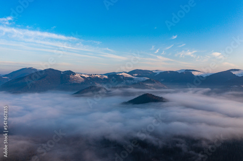 Carpathian peaks in the morning in the clouds, top view, drone footage.