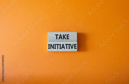 Take initiative symbol. Wooden blocks with words Take initiative. Beautiful orange background. Business and Take initiative concept. Copy space.