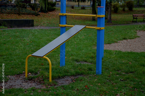 outdoor sports field. exercise equipment with gymnastic rings to strengthen the arms. bench for training the abdominal and back tendons and attachments