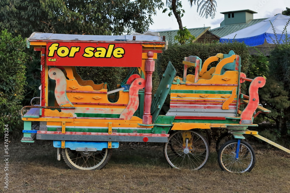 Multicolored carriage for riding children put up for sale. Yungaburra-Australia-273