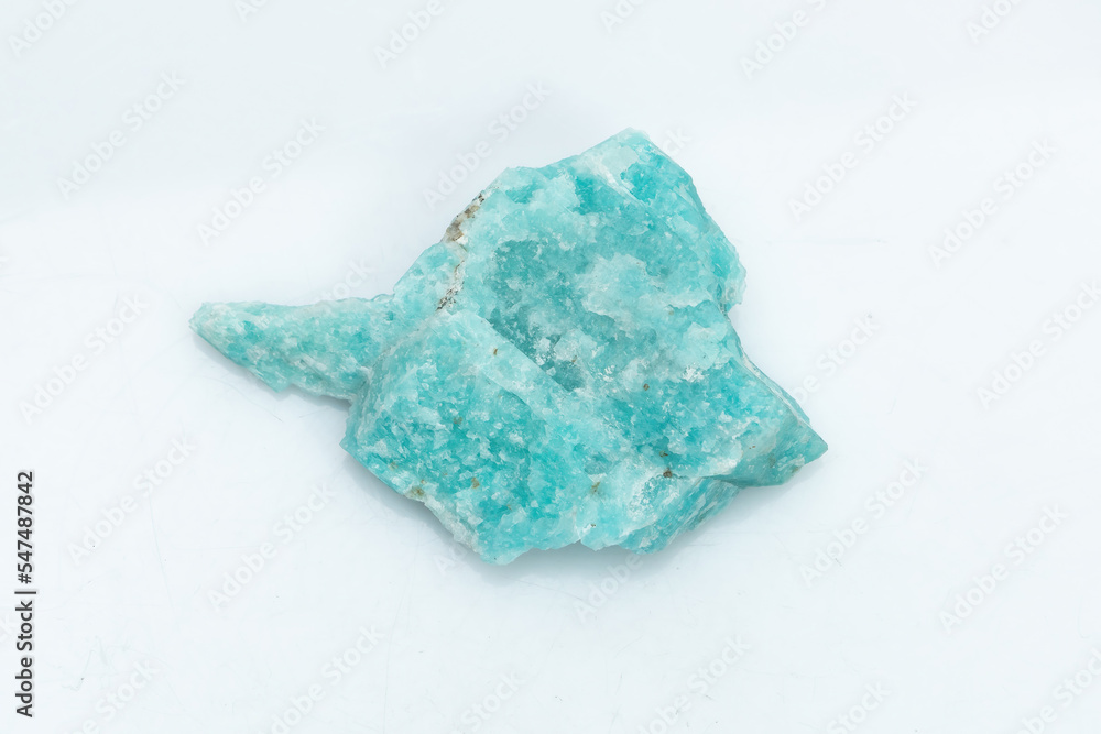 Natural amazonite gemstone isolated on white background. A bluish-green crystal on a white background. A variety of potassium feldspar microcline Natural amazonite gemstone isolated on white background. A bluish-green crystal on a white background. A variety of potassium feldspar microcline
