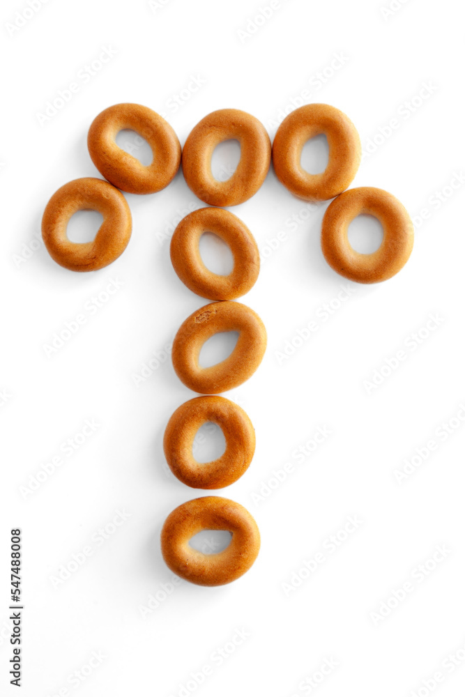 Letter T bagel. Bagels font. Alphabet from set of small dry bagels isolated on white background. ABC symbols. Letter T bagel. Bagels font. Alphabet from set of small dry bagels isolated on white background. ABC symbols.