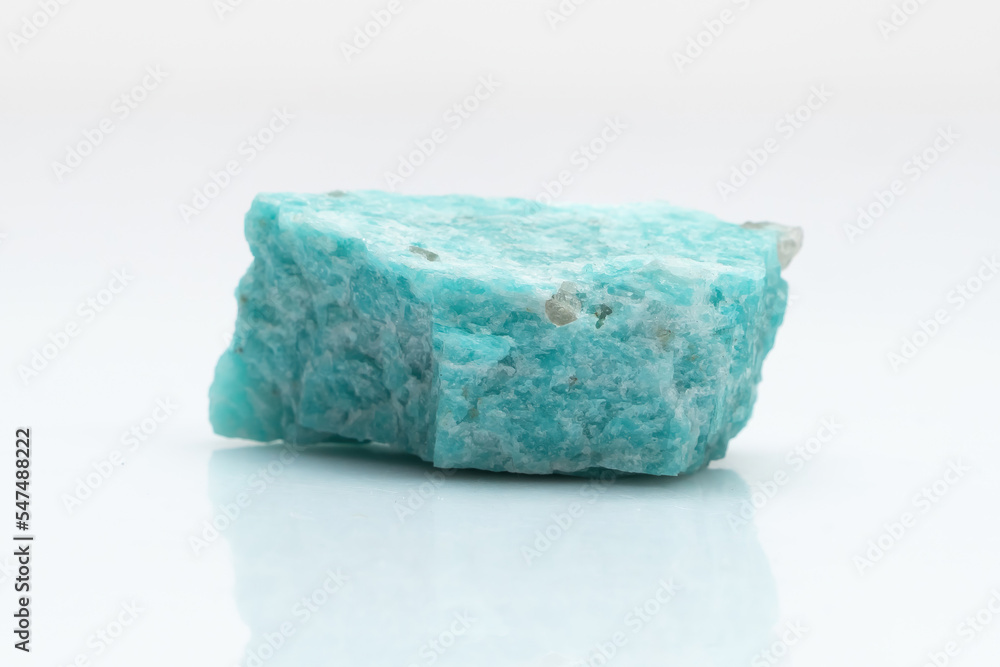 Natural amazonite gemstone isolated on white background. A bluish-green crystal on a white background. A variety of potassium feldspar microcline Natural amazonite gemstone isolated on white background. A bluish-green crystal on a white background. A variety of potassium feldspar microcline