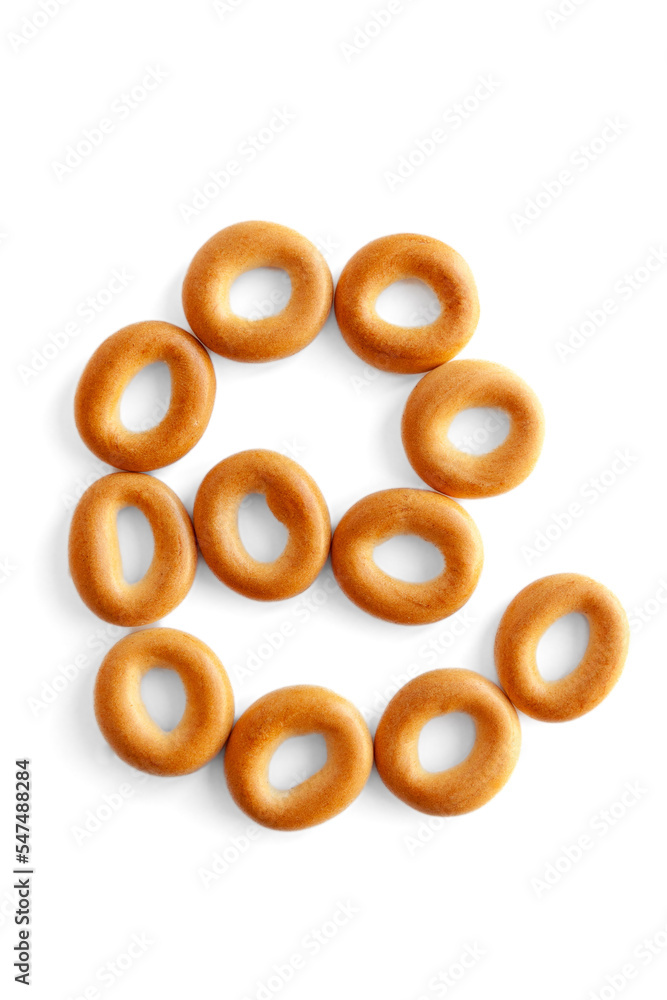 Symbol @ bagel. Bagels font. Alphabet from set of small dry bagels isolated on white background. ABC symbols. Symbol @ bagel. Bagels font. Alphabet from set of small dry bagels isolated on white background. ABC symbols.