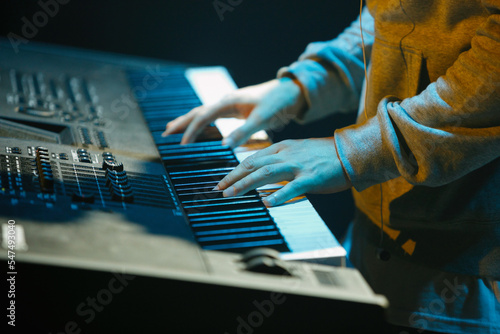 Canvas Print Musician plays music on electronic piano device on stage