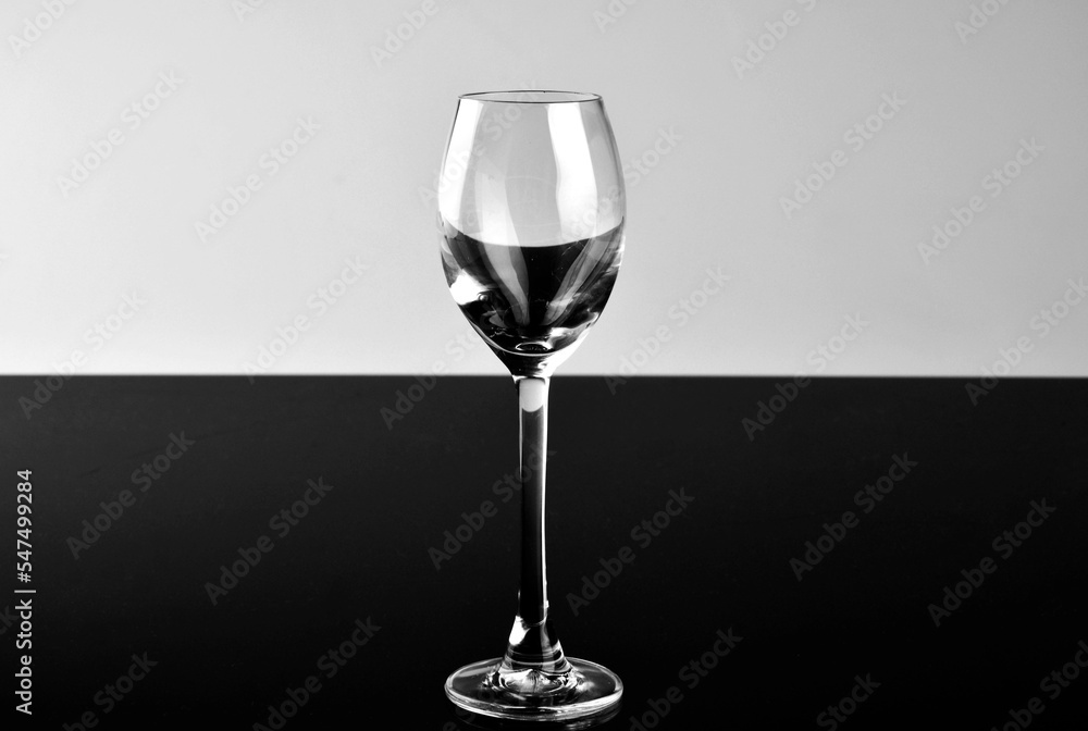 Naklejka premium pusty kieliszek do wina na białym i czarnym tle, czarno-białe tło i szkło, empty wine glass on white and black background, black and white background and glass