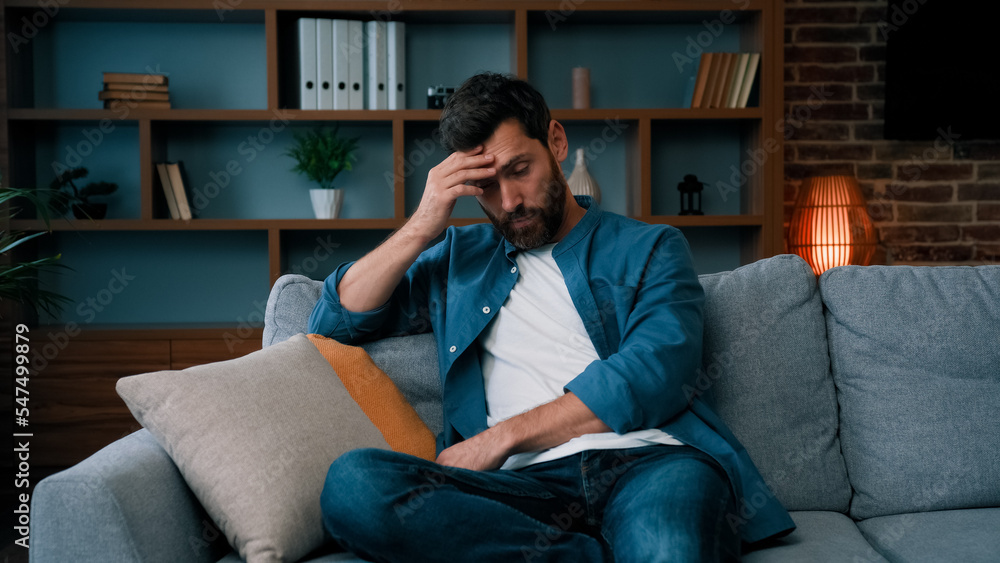 Tired upset father caucasian bearded man sit on sofa frustrated about hard working day at home stressed worried single guy lonely male irritated anxious feel unwell exhaistion lack of energy stress Tired upset father caucasian bearded man sit on sofa frustrated about hard working day at home stressed worried single guy lonely male irritated anxious feel unwell exhaistion lack of energy stress
