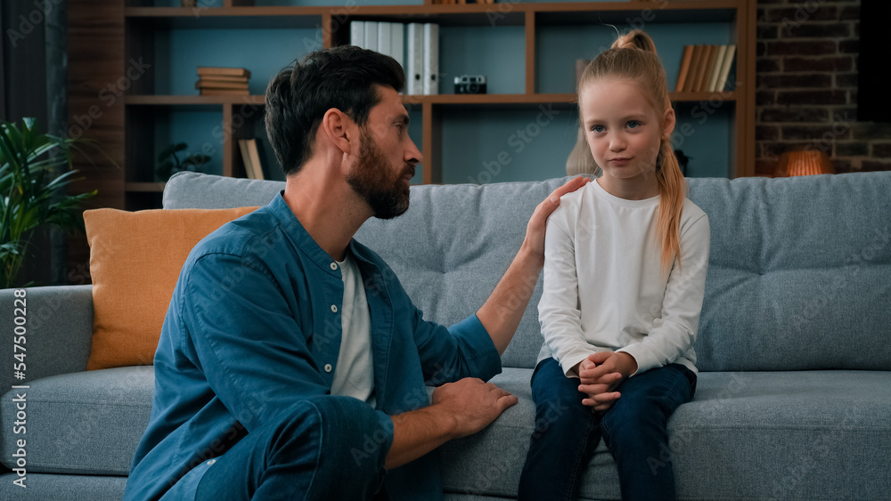 Loving caring father dad babysitter parent apologize to offended daughter girl at home professional psychologist man talk with naughty upset child. Two diverse people have quarrel conflict in family - obrazy, fototapety, plakaty 