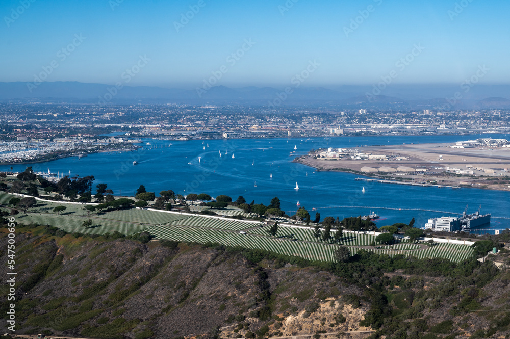Aerial view of Fort RoseCrans cemetery in San Diego California with Coronado military base and sailboats in the background