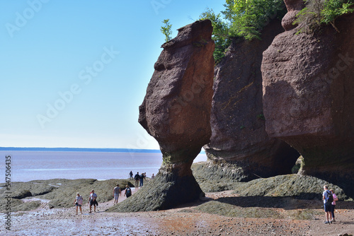 HOPEWELL CAPE, NEW BRUNSWICK, CANADA - August 15, 2022 - Sea stacks at low tide with tourist. Rock tower also called flowerpots.