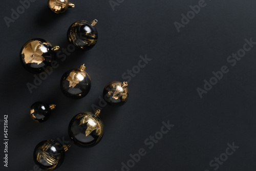 Christmas black baubles decorative golden plated potal leaf with bokeh on black background. Xmas banner with copy space. Modern luxury Christmas card. photo