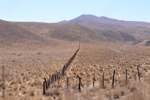 Fence with barbed wire and sand dunes at north Argentina desert