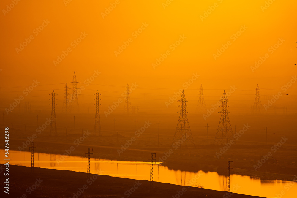 High voltage power lines and transmission towers at golden sunset. Industry energy supply concept