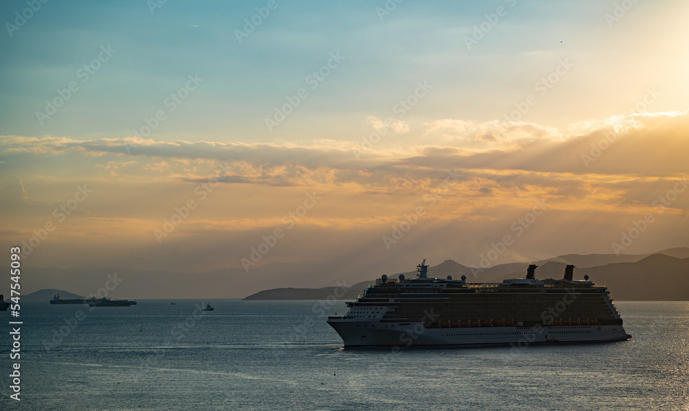 luxury cruise ships passing by island during golden sunset. Travel, voyage and vacation concept luxury cruise ships passing by island during golden sunset. Travel, voyage and vacation concept