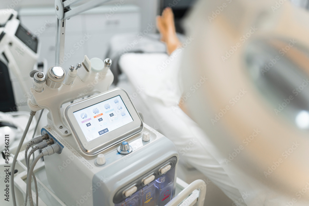 Technology and evolution in taking care of one's body and skin. Professional white skincare treatment equipment machine. Blurred right side of foreground. High quality photo Technology and evolution in taking care of one's body and skin. Professional white skincare treatment equipment machine. Blurred right side of foreground. High quality photo