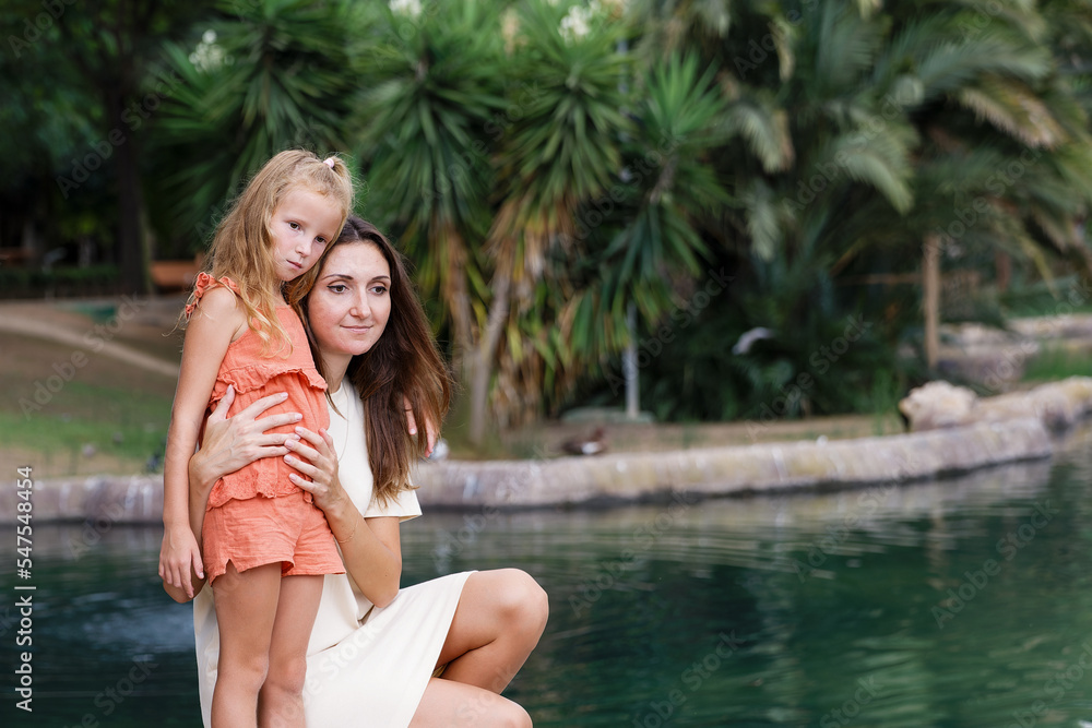 Obraz premium A mother with children walks in a city park, family vacation, the concept of a healthy lifestyle and family leisure