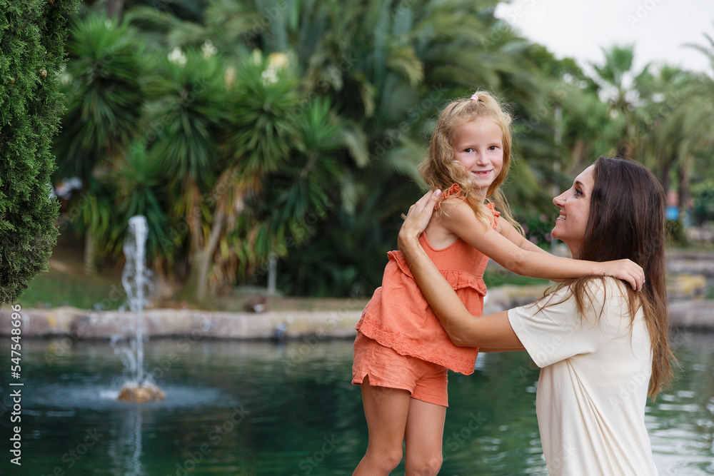 A mother with children walks in a city park, family vacation, the concept of a healthy lifestyle and family leisure A mother with children walks in a city park, family vacation, the concept of a healthy lifestyle and family leisure