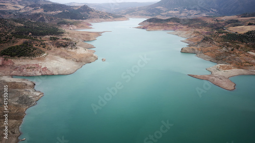 Aerial drone view of low levels of the dam river. Shortage of water. Climate change. Severe drought. Global warming. Environmental disaster. No water to dry agriculture fields. 