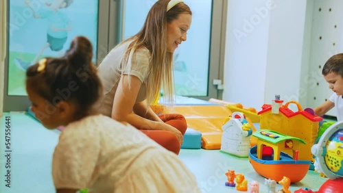 little kids and their beloved teacher having a great time together at the nursery. High quality 4k footage photo