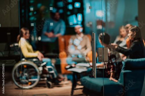 Businesswoman in wheelchair having business meeting with team at modern office. A group of young freelancers agree on new online business projects © .shock
