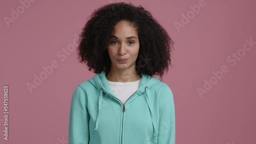 Close-up shot view of mixed-race, emotional woman looking at camera. Woman nodding and smiling, making a positive facial expression. High quality 4k footage