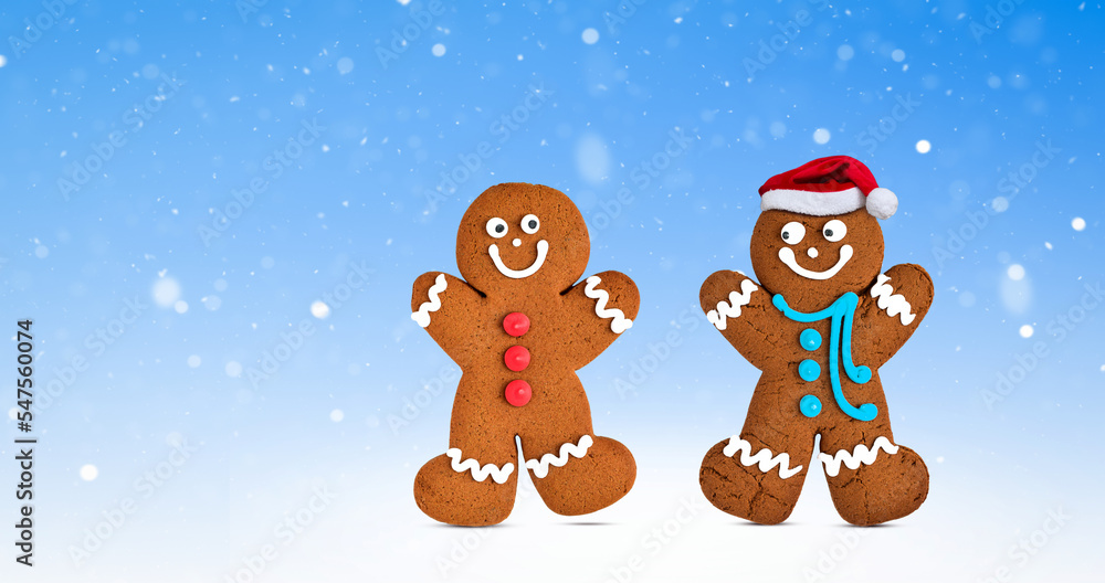 Happy two gingerbread cookie characters on wintery blue background with snow