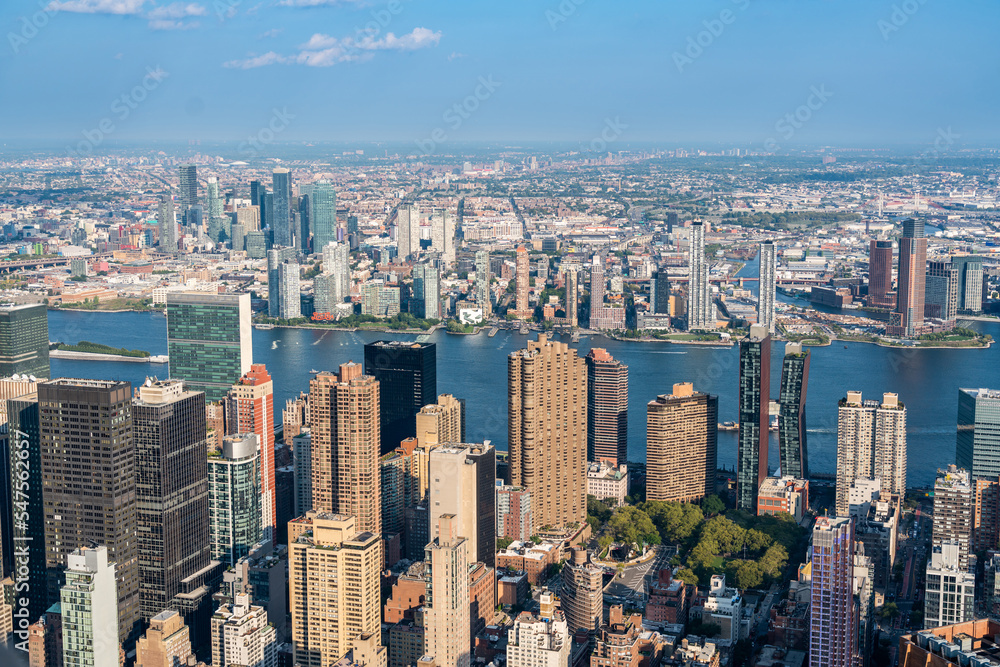 Boroughs of Brooklyn across the East River behind the skyscrapers of Manhattan aerial view