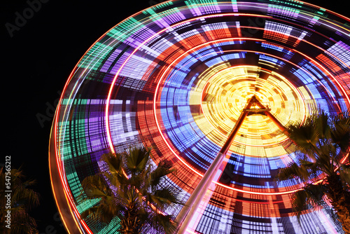 Beautiful glowing Ferris wheel against dark sky  low angle view