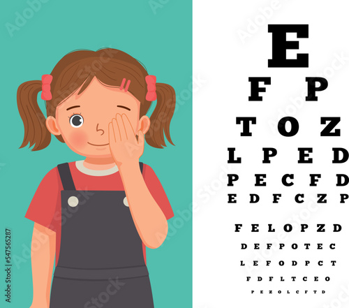 Cute little girl cover her eye having vision test reading block letters at ophthalmologist office