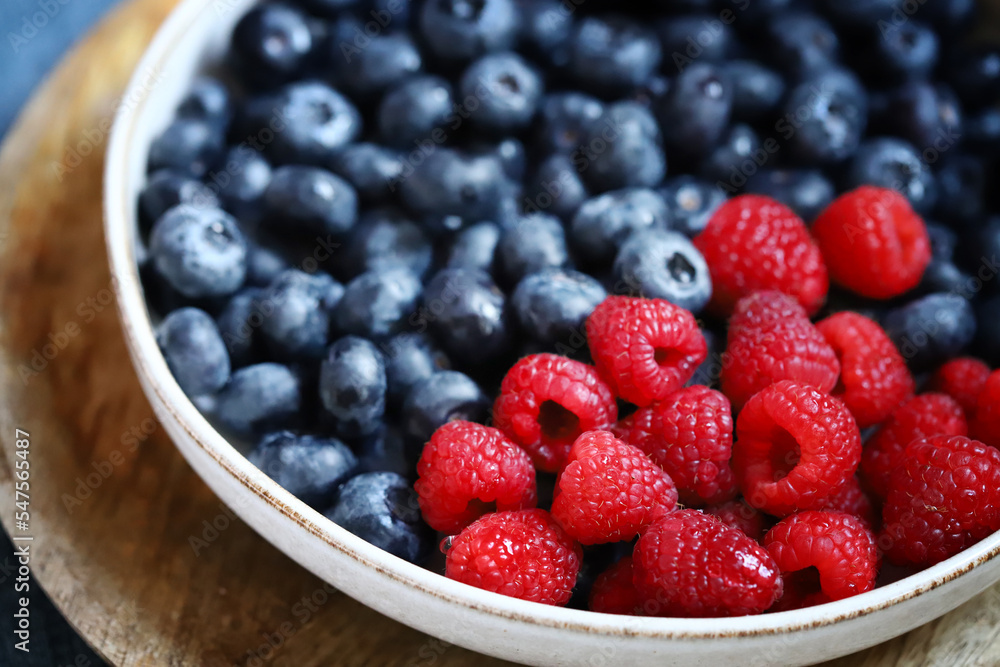 Fresh selected raspberries and blueberries in a bowl. Healthy snack. Berries for dessert. Close-up. Fresh selected raspberries and blueberries in a bowl. Healthy snack. Berries for dessert. Close-up.