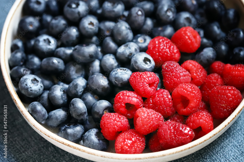 Fresh selected raspberries and blueberries in a bowl. Healthy snack. Berries for dessert. Close-up. Fresh selected raspberries and blueberries in a bowl. Healthy snack. Berries for dessert. Close-up.