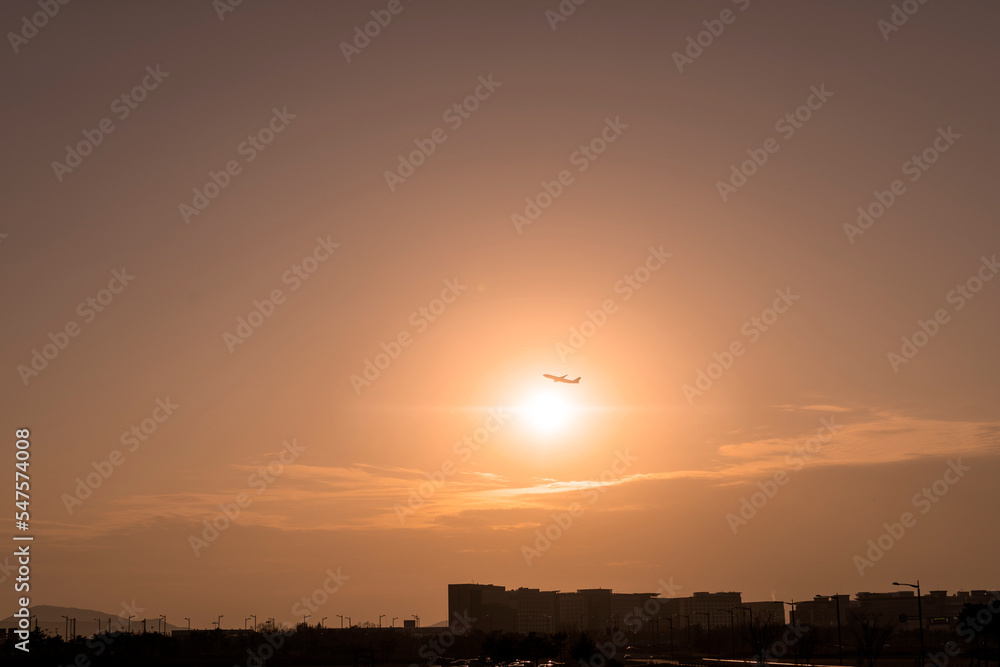 Sunset view with airplane flying in the sky