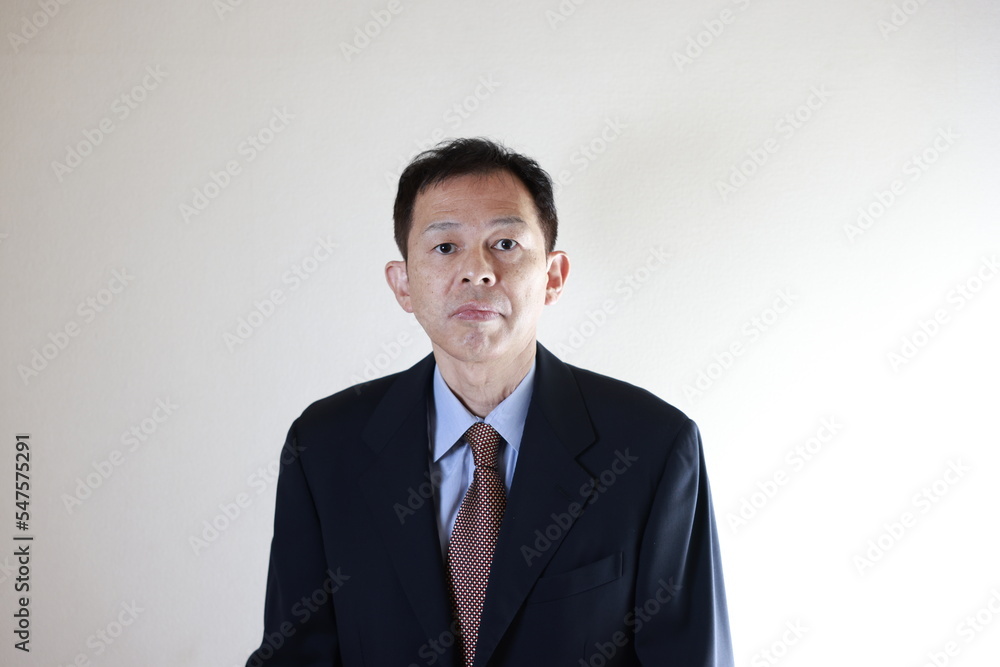 Middle-aged Japanese male businessman wearing navy blue suit on white background. Conceptual image of a project proposal, strategic business success and negotiation closing. Middle-aged Japanese male businessman wearing navy blue suit on white background. Conceptual image of a project proposal, strategic business success and negotiation closing.