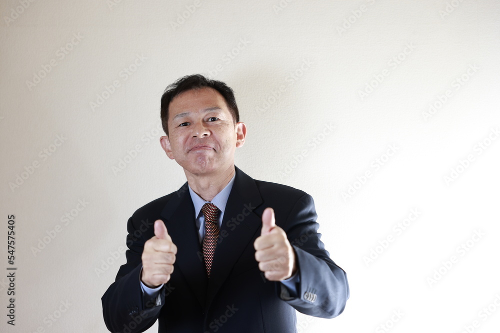 Middle-aged Japanese male businessman wearing navy blue suit on white background. Conceptual image of a project proposal, strategic business success and negotiation closing. Middle-aged Japanese male businessman wearing navy blue suit on white background. Conceptual image of a project proposal, strategic business success and negotiation closing.