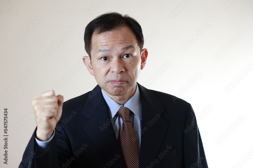 Middle-aged Japanese male businessman wearing navy blue suit on white background. Conceptual image of a project proposal, strategic business success and negotiation closing. Middle-aged Japanese male businessman wearing navy blue suit on white background. Conceptual image of a project proposal, strategic business success and negotiation closing.