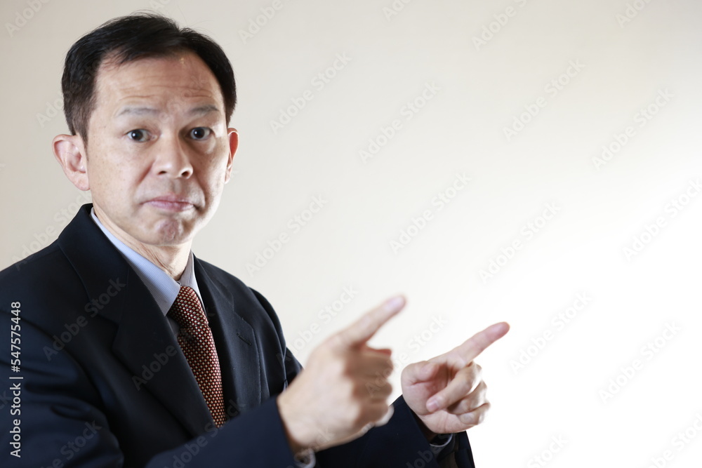 Middle-aged Japanese male businessman wearing navy blue suit on white background. Conceptual image of a project proposal, strategic business success and negotiation closing. Middle-aged Japanese male businessman wearing navy blue suit on white background. Conceptual image of a project proposal, strategic business success and negotiation closing.