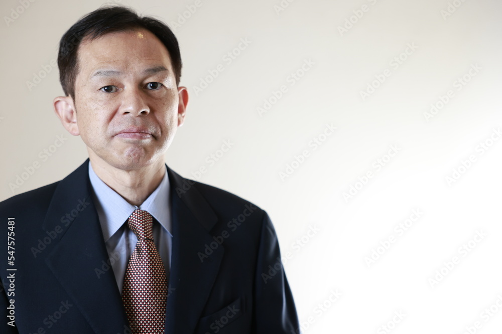 Middle-aged Japanese male businessman wearing navy blue suit on white background. Conceptual image of a project proposal, strategic business success and negotiation closing. Middle-aged Japanese male businessman wearing navy blue suit on white background. Conceptual image of a project proposal, strategic business success and negotiation closing.