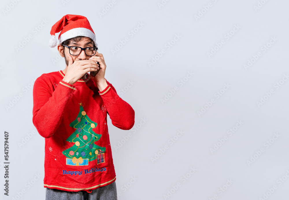 Man in christmas hat talking on the phone secretly. Christmas guy talking on the phone secretly, Christmas person talking on the phone secretly covering his mouth Man in christmas hat talking on the phone secretly. Christmas guy talking on the phone secretly, Christmas person talking on the phone secretly covering his mouth