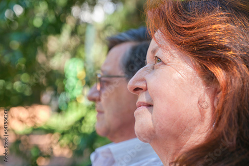 Senior Hispanic couple enjoying time together in a park, outdoors. Selective focus on her. Concepts: enjoyment of nature, active retirement, plans for the future.