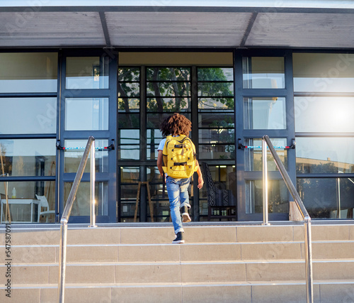 Fotografija Child, walking and school entrance for education, learning or childhood development at academy building