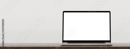 Foto Laptop on wooden table, white wall