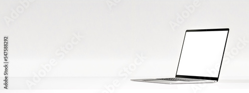 Laptop with blank screen on white table on white wall background. Modern Laptop silver metallic color mockup. Wide web banner. copy space