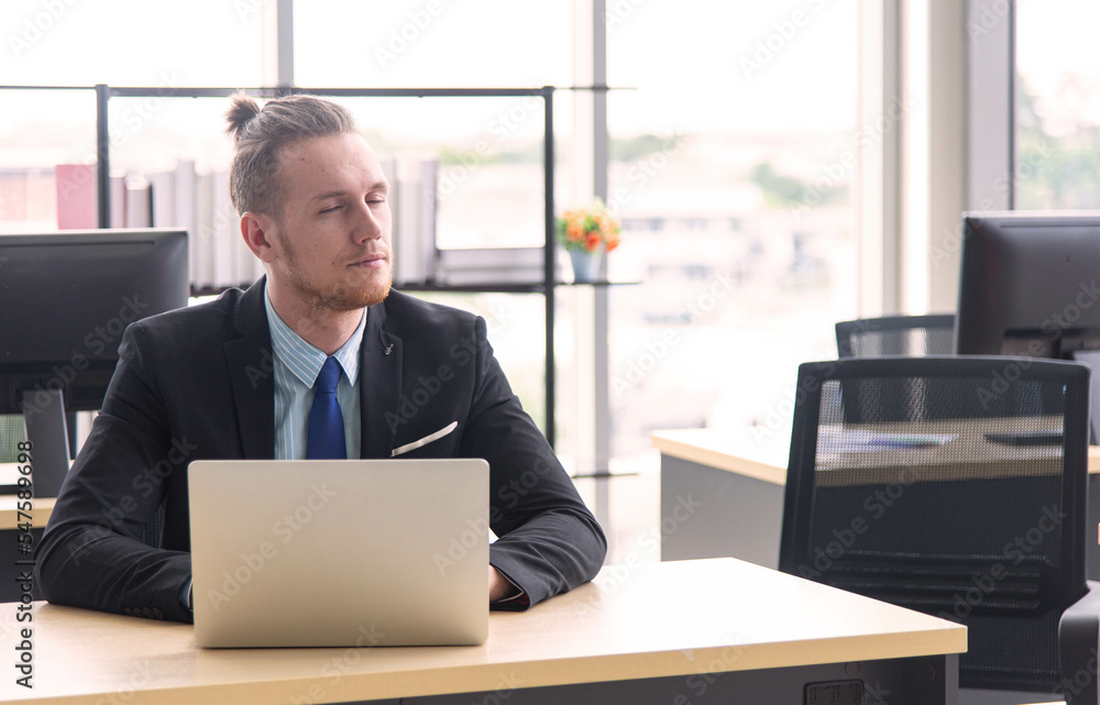Young businessman closing eyes for take a rest from hard work Young businessman closing eyes for take a rest from hard work
